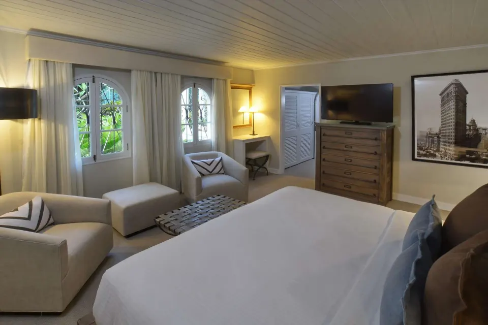 Two-bedroom suite bedroom with king bed and seating area at Fairmont Royal Pavilion.