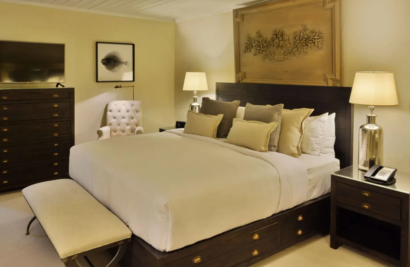 Two-bedroom suite bedroom with king bed and bedside lamps at Fairmont Royal Pavilion.