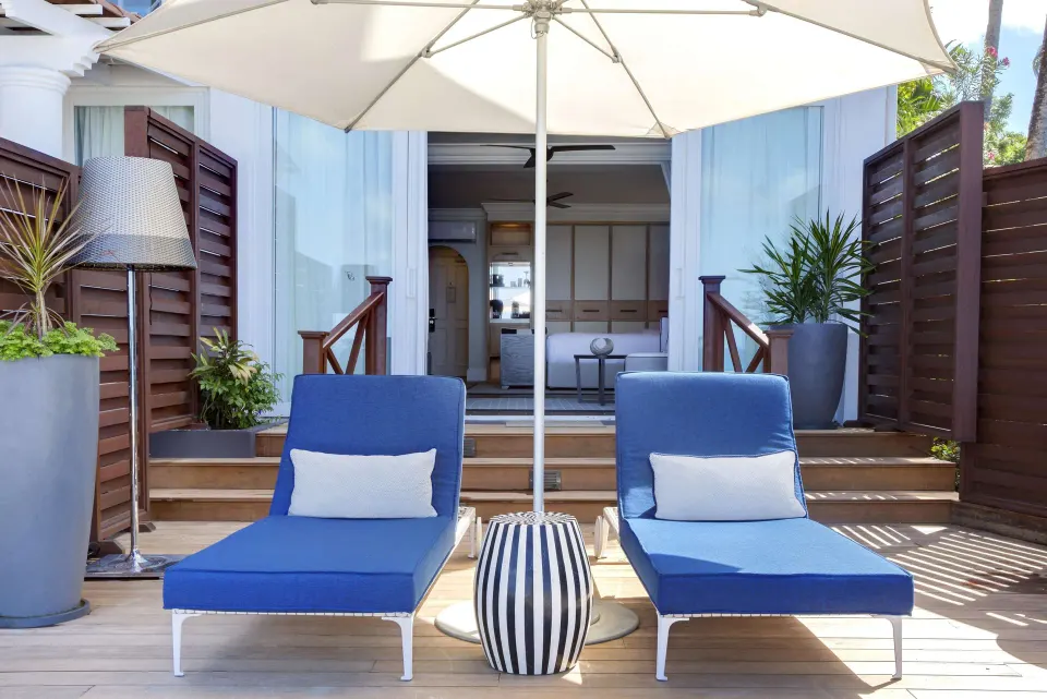 Private beachfront suite deck with blue loungers at Fairmont Royal Pavilion.
