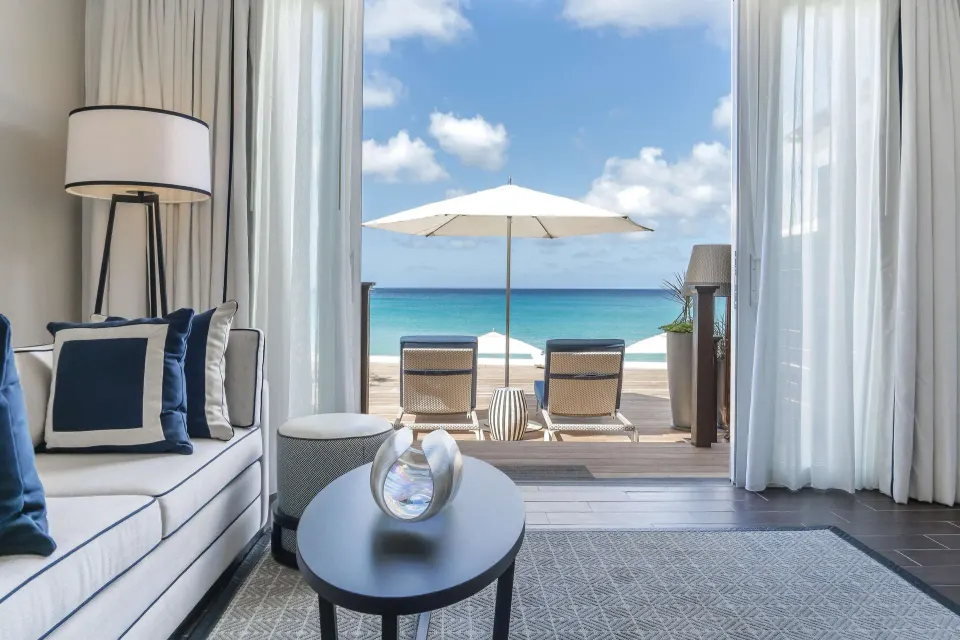 Beachfront accessible suite sitting area opening to the ocean at Fairmont Royal Pavilion.