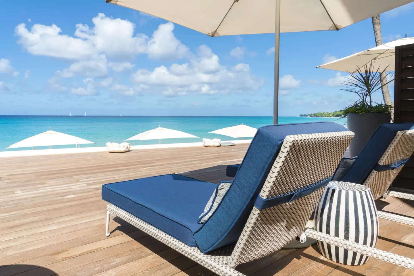 Beachfront suite deck with blue loungers and ocean view at Fairmont Royal Pavilion.