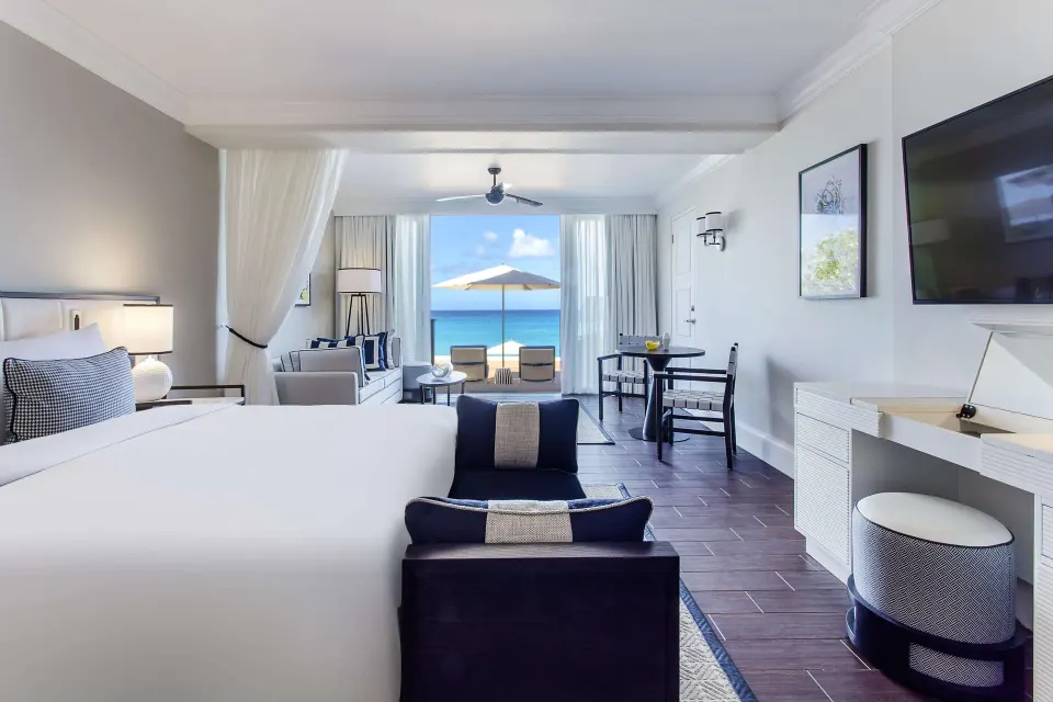 Beachfront suite with king bed, desk and ocean-facing terrace at Fairmont Royal Pavilion.
