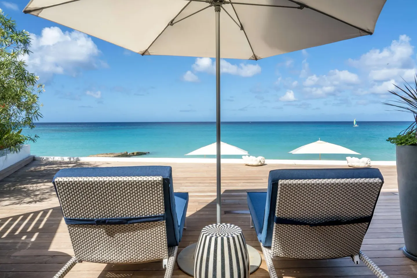 Beachfront suite terrace with loungers and ocean view at Fairmont Royal Pavilion.