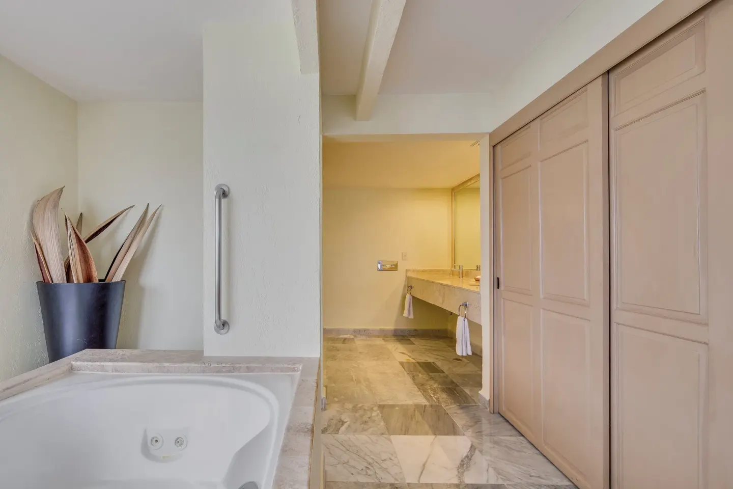 Bathroom with jetted tub, closet doors, and vanity at Fiesta Americana Cancun Villas.