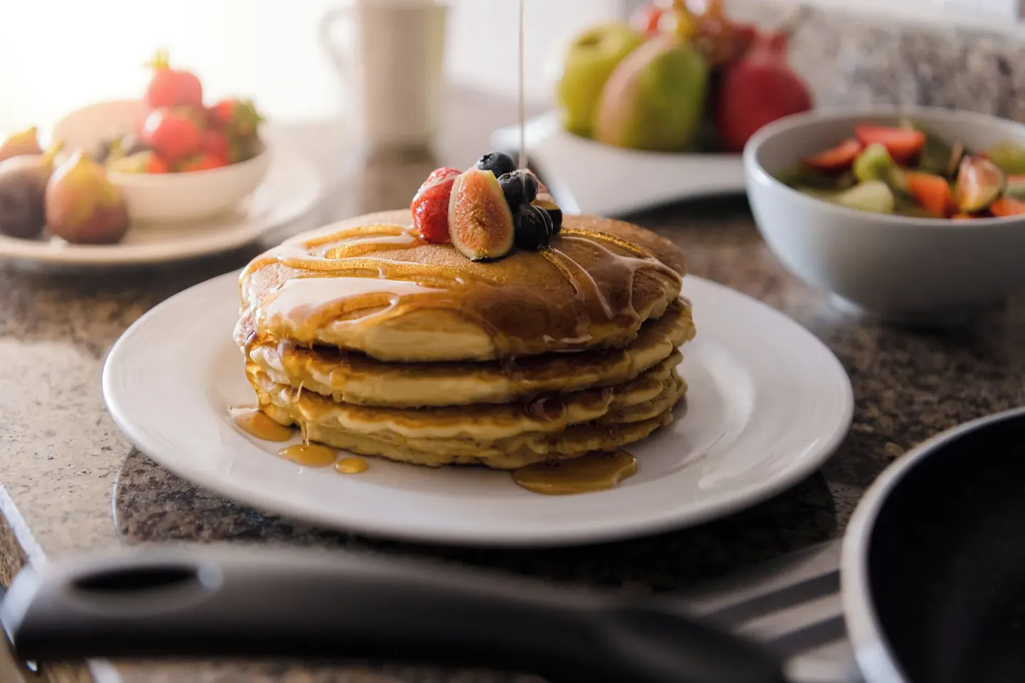 Pancakes with syrup and fruit on a kitchen counter at Fiesta Americana Cancun Villas.