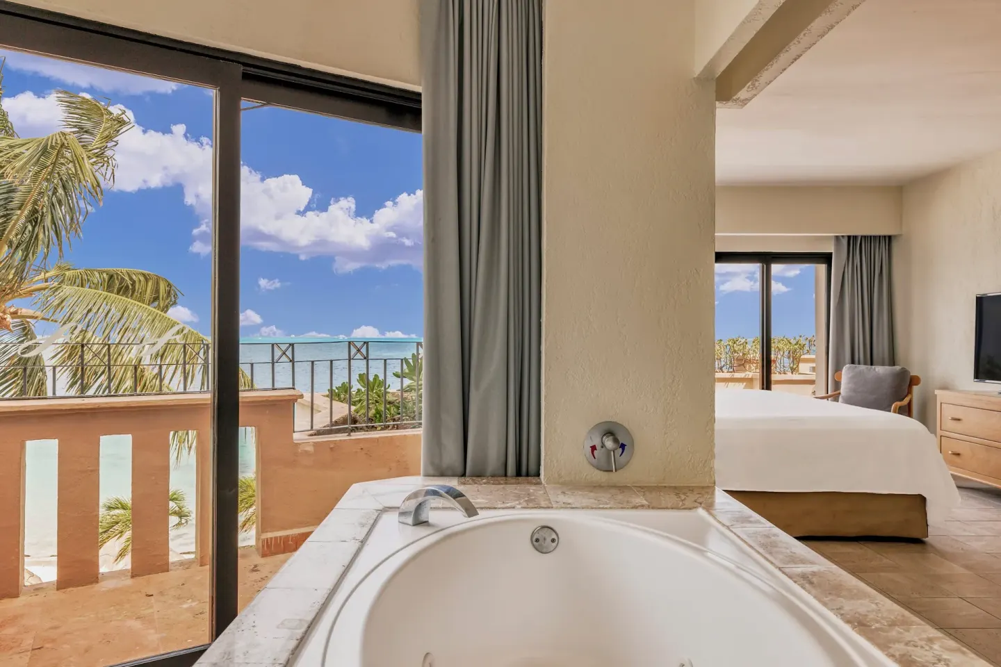 Ocean-view guest room with soaking tub and king bed at Fiesta Americana Cancun Villas.