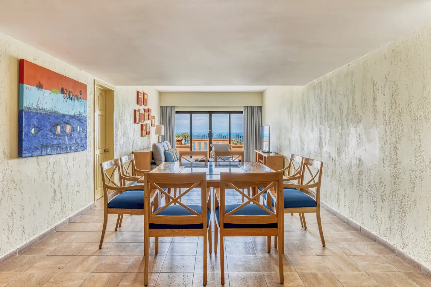 Suite dining table and living area opening to an ocean terrace at Fiesta Americana Cancun Villas.