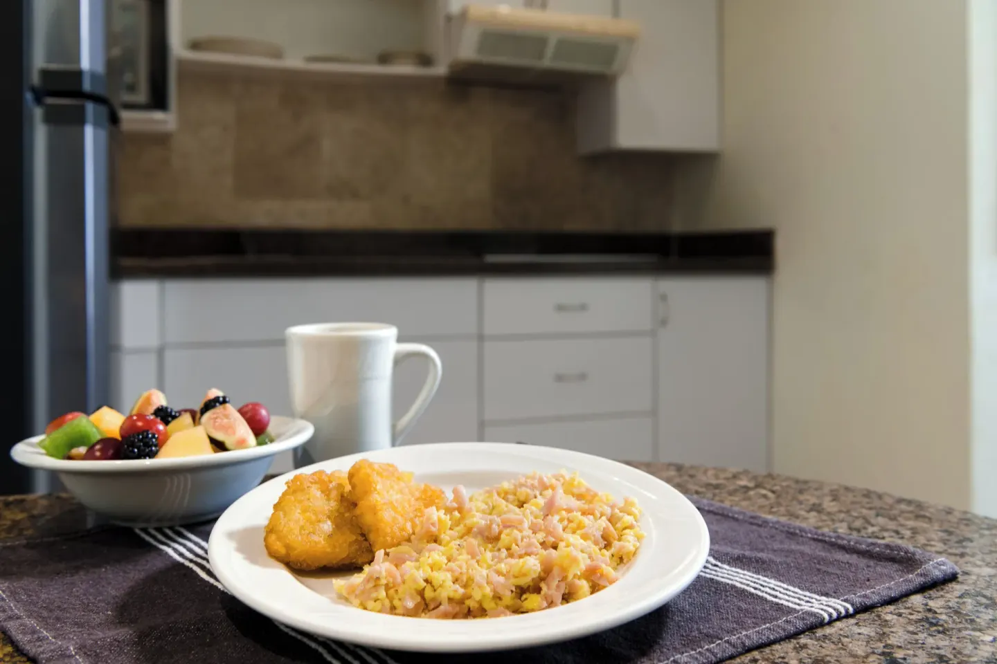 Breakfast plate and fruit bowl in a suite kitchen at Fiesta Americana Cancun Villas.