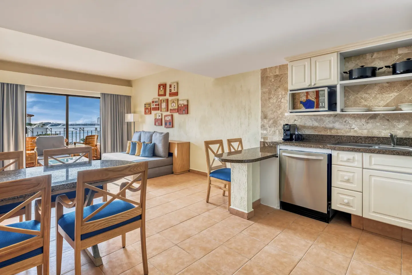 Open suite kitchen, dining space, sofa, and balcony view at Fiesta Americana Cancun Villas.