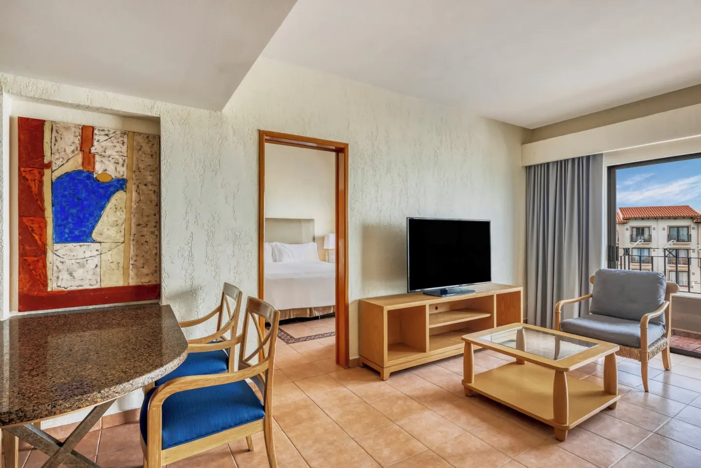 Living area with TV, balcony doors, and bedroom doorway at Fiesta Americana Cancun Villas.