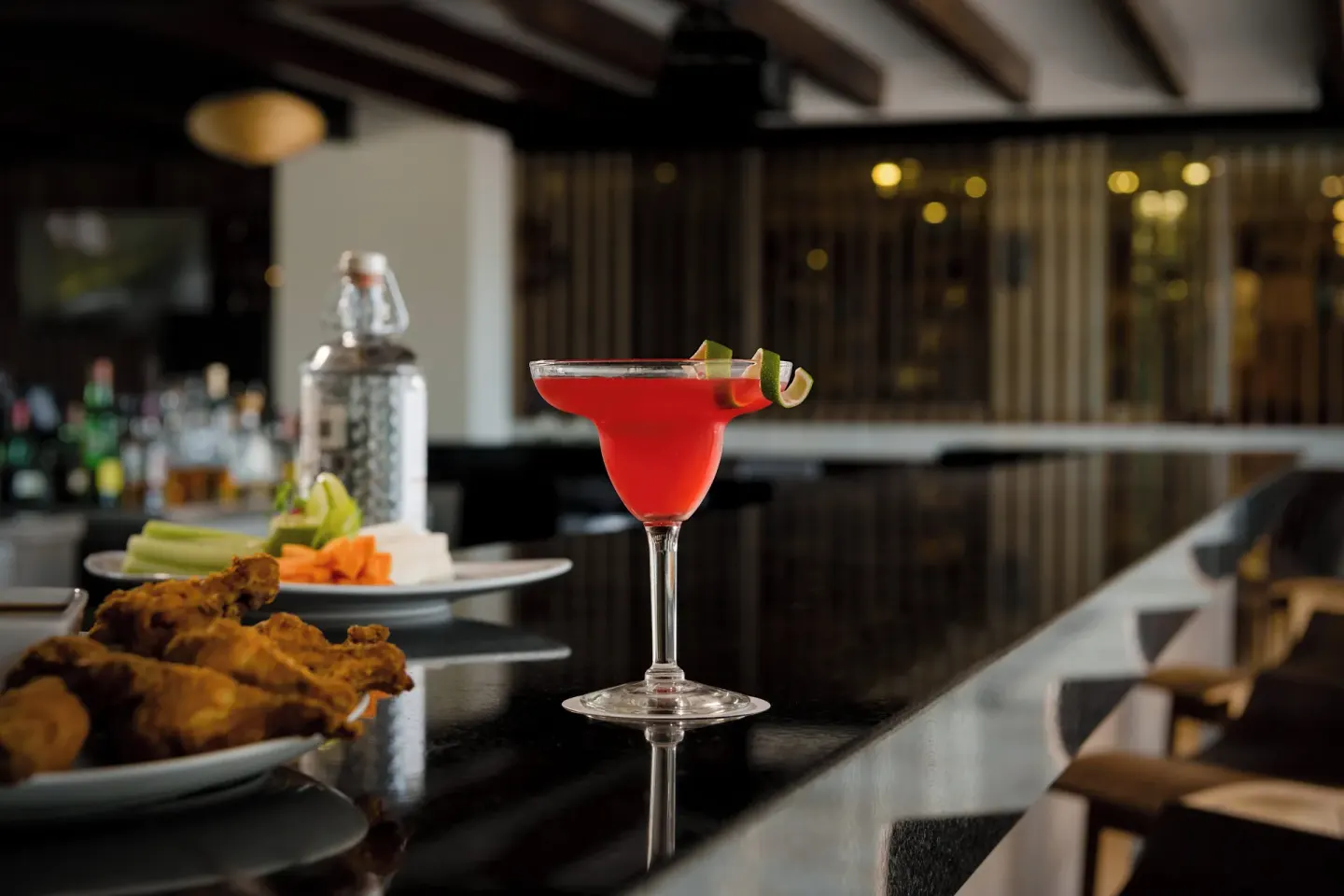 Red cocktail with lime garnish on a bar at Fiesta Americana Cancun Villas.