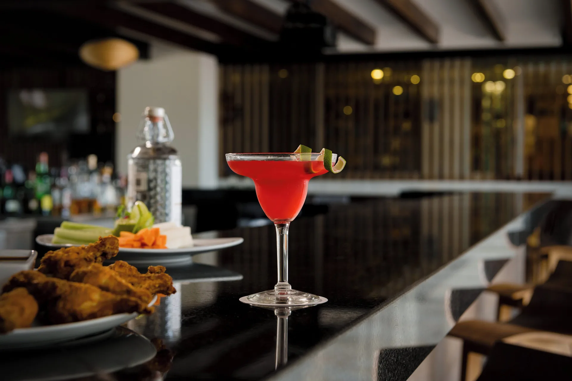 Red cocktail with lime garnish on a bar at Fiesta Americana Cancun Villas.
