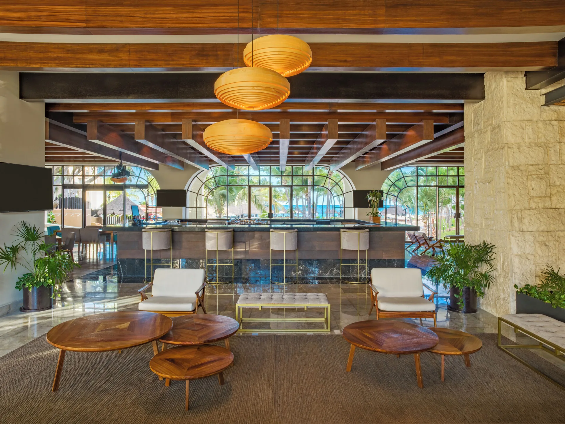 Lobby bar with counter seating and lounge tables at Fiesta Americana Cancun Villas.