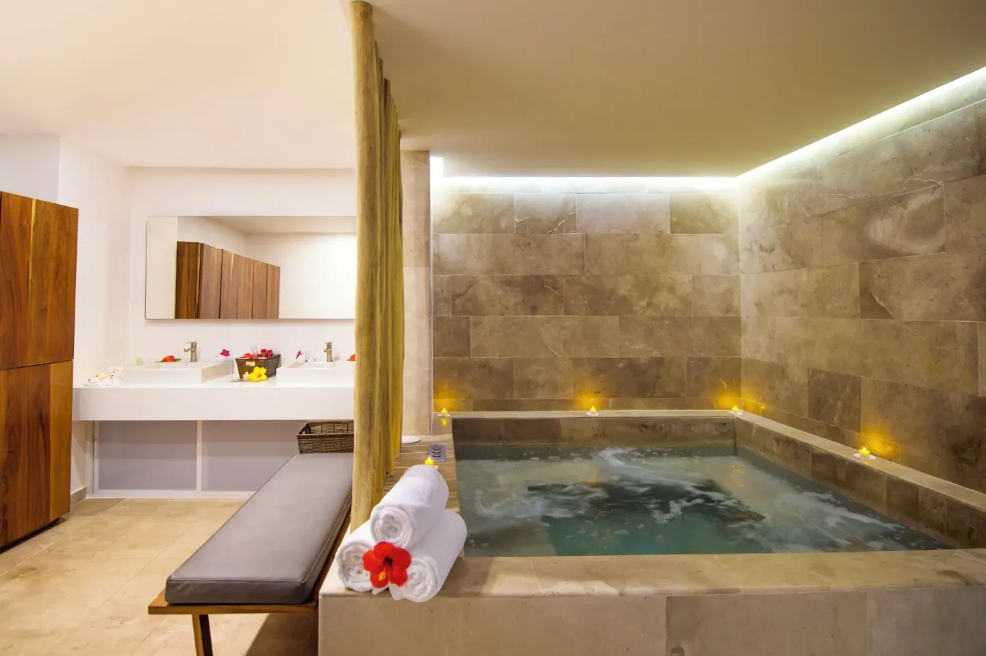 Spa soaking pool with candles, towels, and double sinks at Fiesta Americana Cozumel.