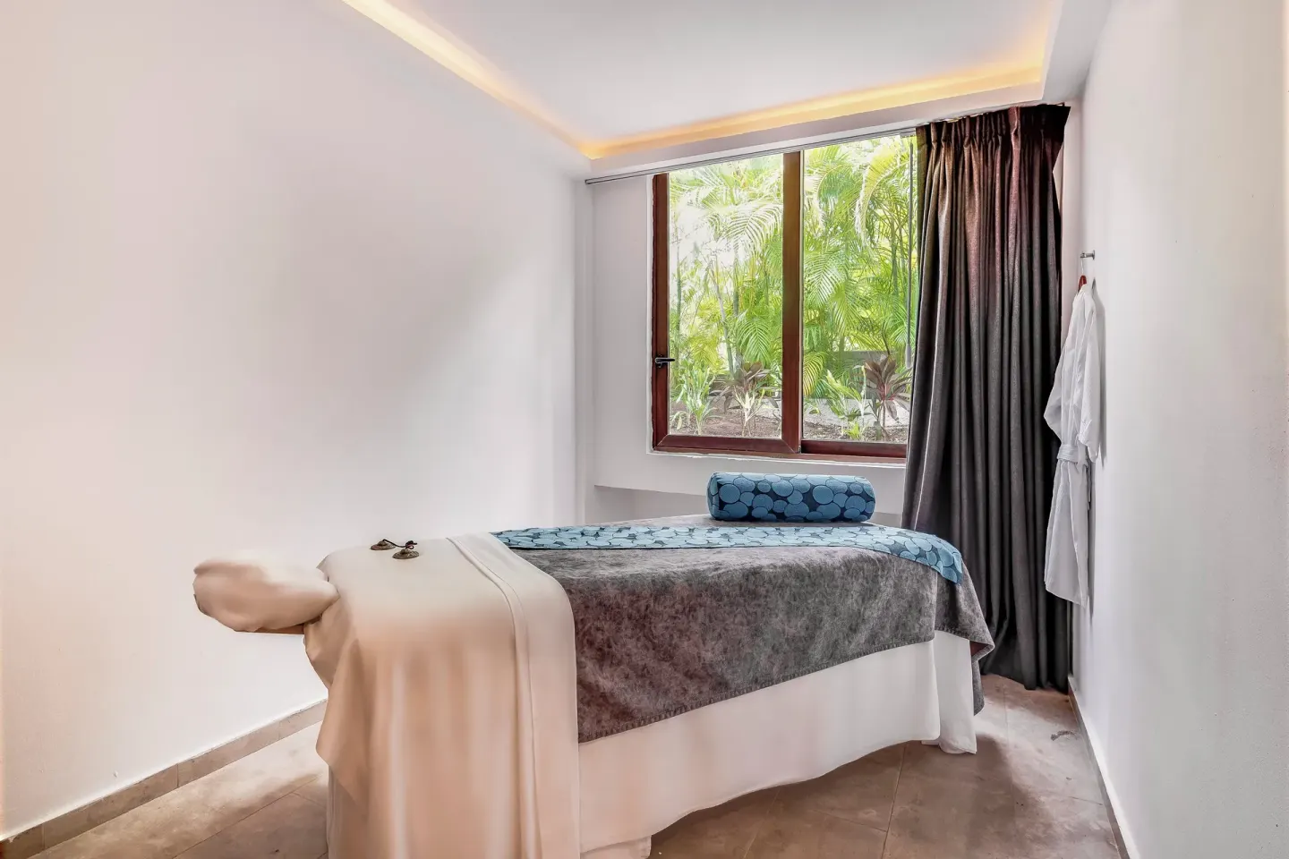 Massage treatment room with a single bed and garden window at Fiesta Americana Cozumel.