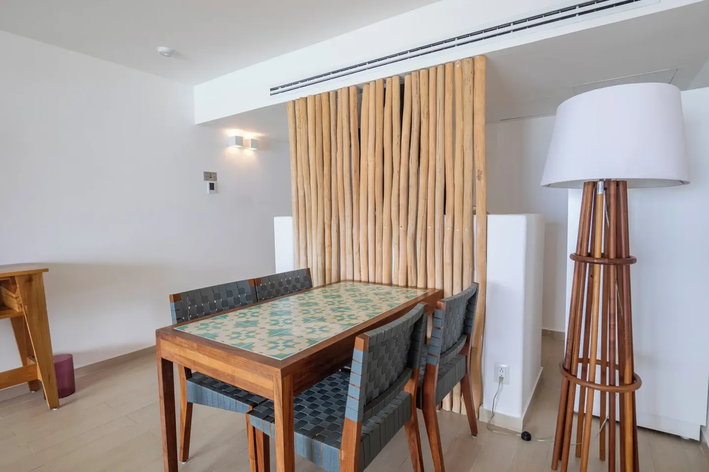 Suite dining nook with wooden table and floor lamp at Fiesta Americana Cozumel.