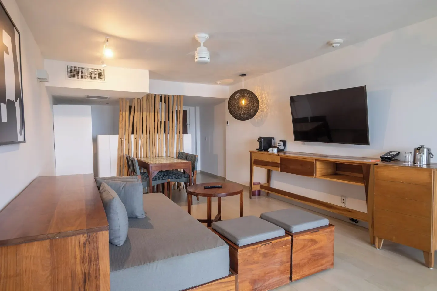 Suite living area with sofa, TV, and dining nook at Fiesta Americana Cozumel.