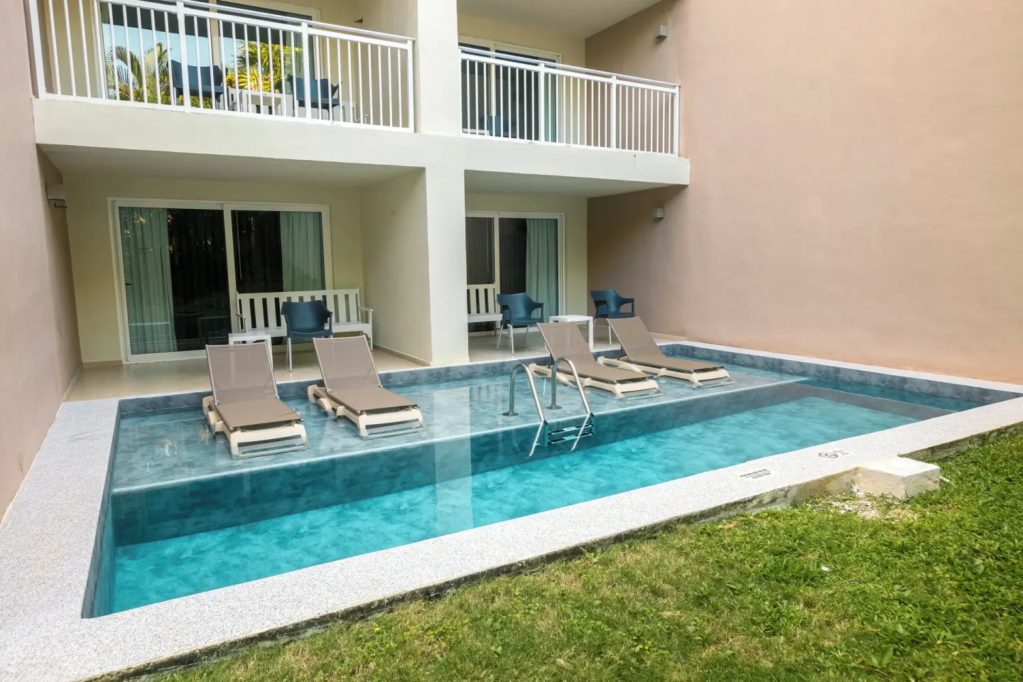 Swim-up pool with lounge chairs, patios, and balconies at Fiesta Americana Cozumel.
