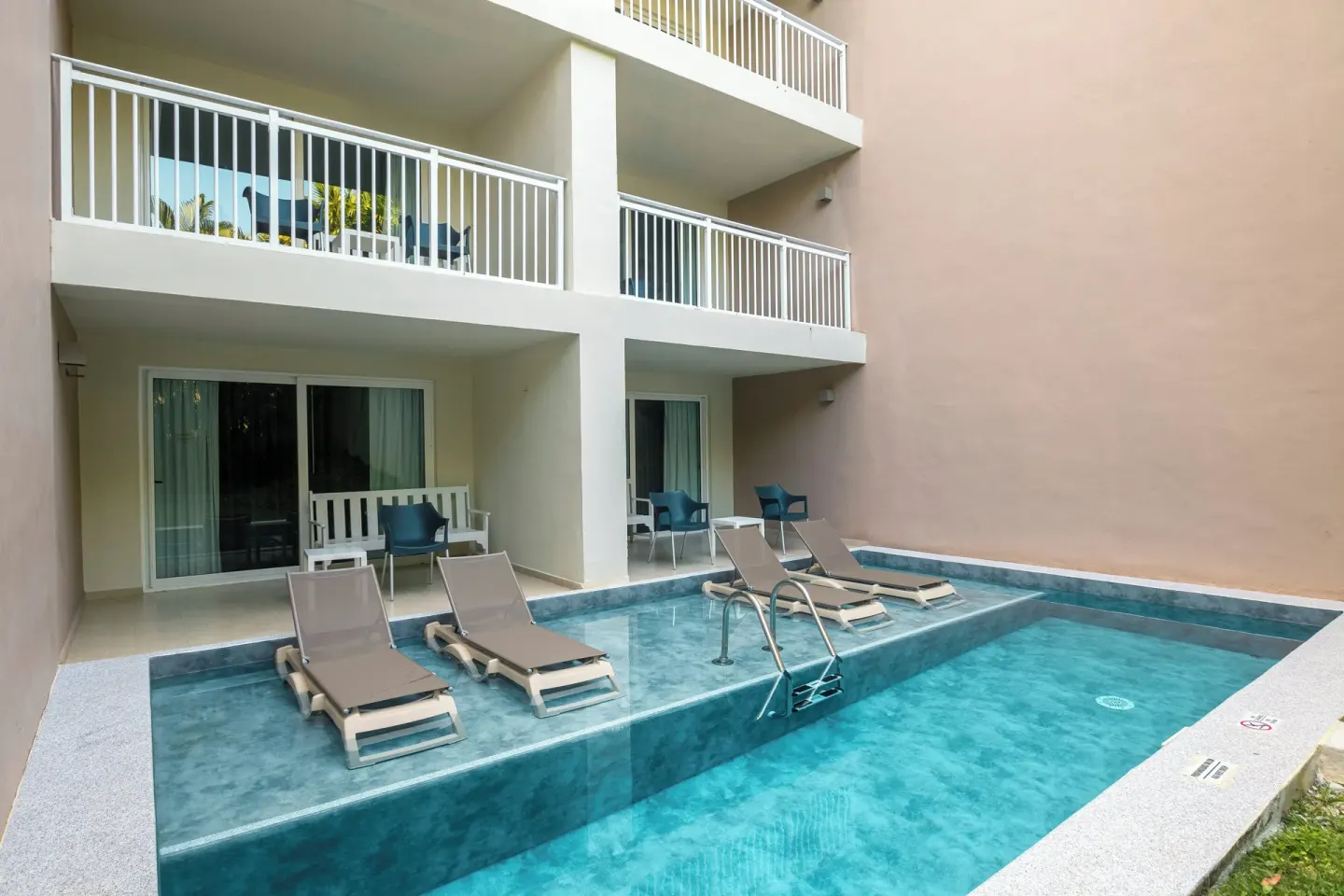 Swim-up pool area with loungers and room patios at Fiesta Americana Cozumel.