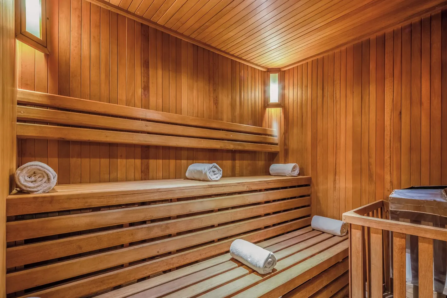 Wood-paneled sauna with benches and rolled towels at Fiesta Americana Cozumel.