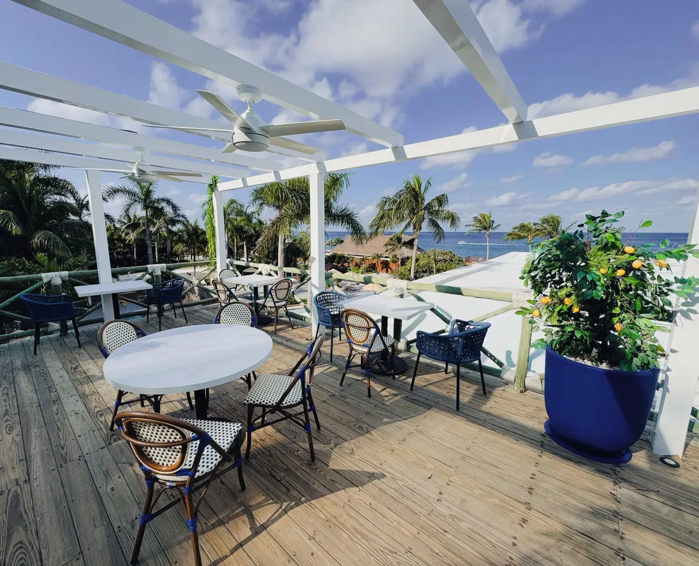 Open-air terrace with café tables and ocean view at Fiesta Americana Cozumel.