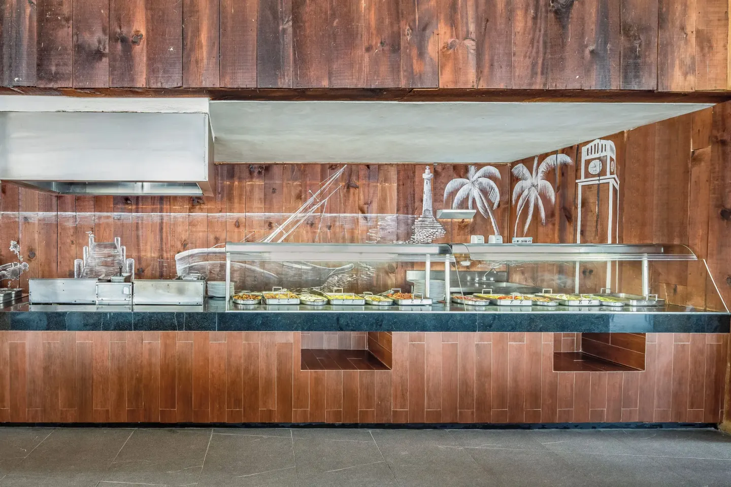 Buffet counter with wood wall mural at Fiesta Americana Cozumel.