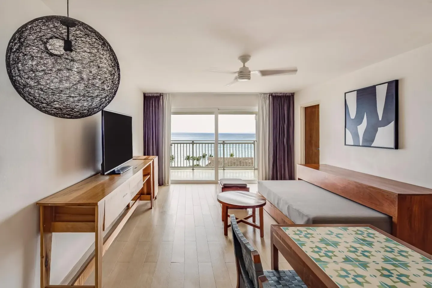 Deluxe Ocean View sitting area with sofa and balcony at Fiesta Americana Cozumel.