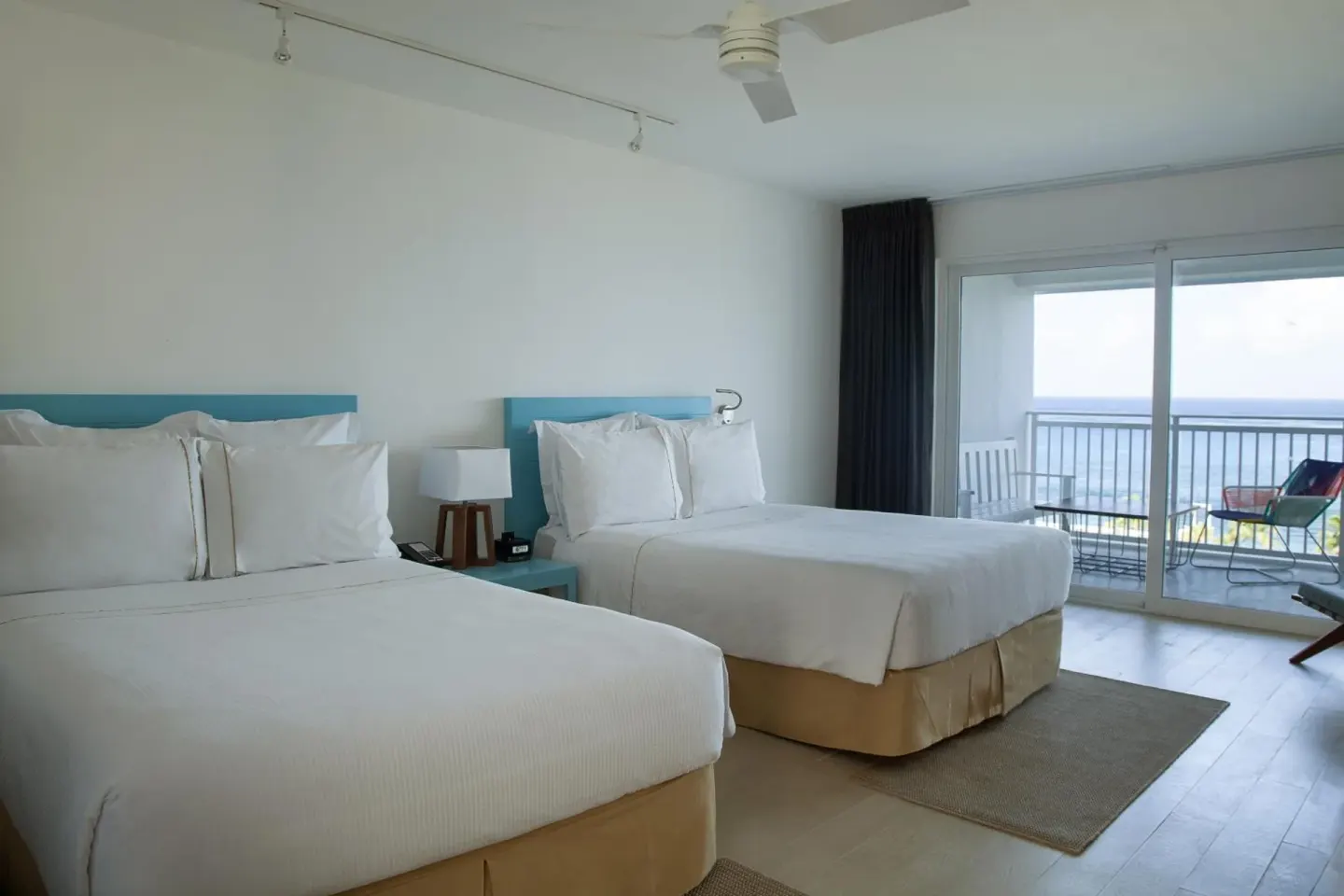 Deluxe Ocean View room with two beds and balcony seating at Fiesta Americana Cozumel.