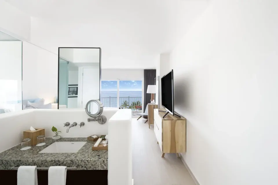 Deluxe Ocean View vanity, TV console, and balcony view at Fiesta Americana Cozumel.