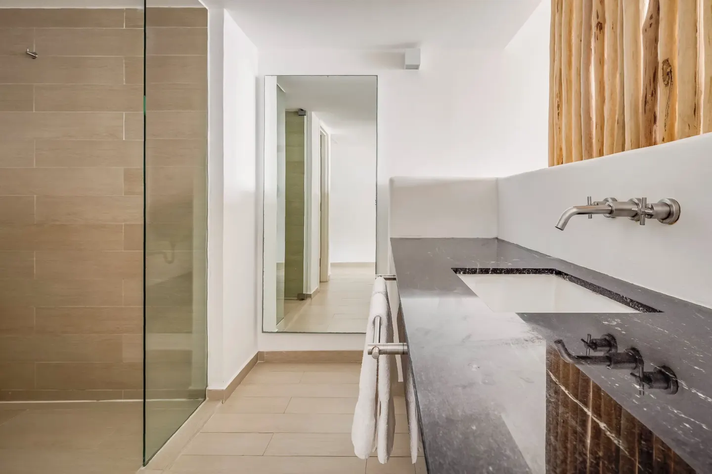 Deluxe ocean view room bathroom with shower and stone vanity at Fiesta Americana Cozumel.