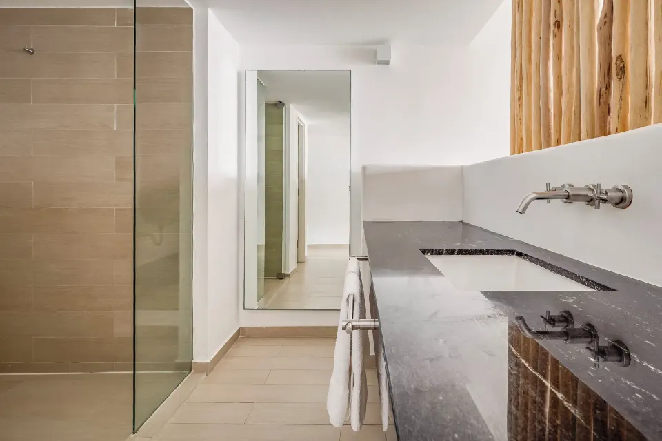 Deluxe ocean view room bathroom with shower and stone vanity at Fiesta Americana Cozumel.