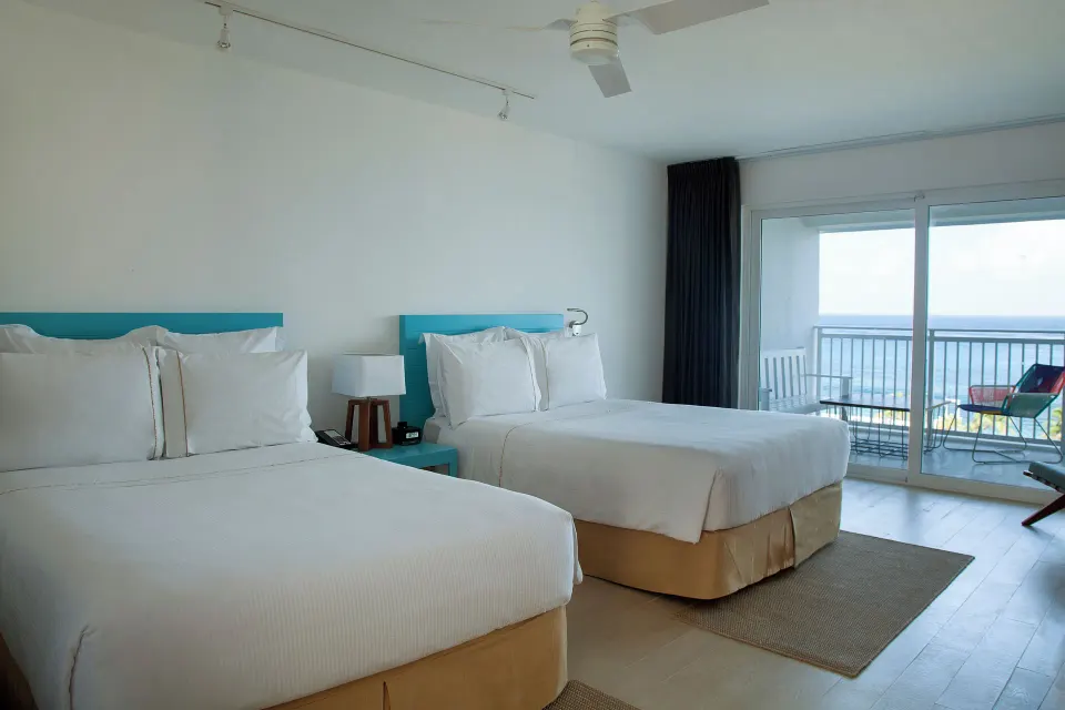 Deluxe ocean view room with two beds and balcony at Fiesta Americana Cozumel.