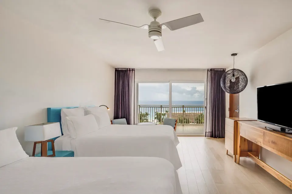 Deluxe ocean view room with two beds and sea-facing balcony at Fiesta Americana Cozumel.