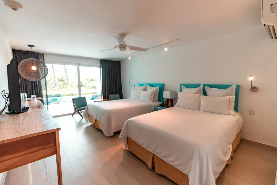 Bedroom with two double beds and terrace pool access at Fiesta Americana Cozumel.