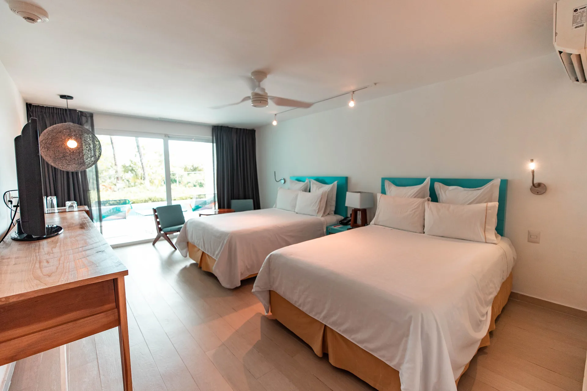 Bedroom with two double beds and terrace pool access at Fiesta Americana Cozumel.