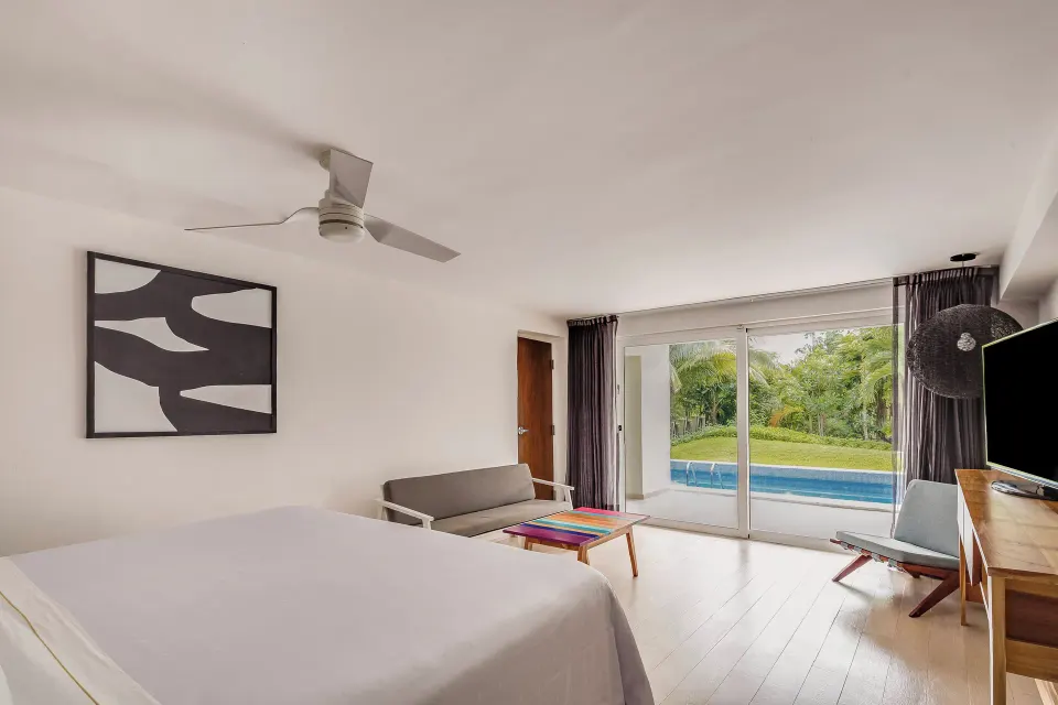 Master Suite king bed and seating area by a plunge pool at Fiesta Americana Cozumel.