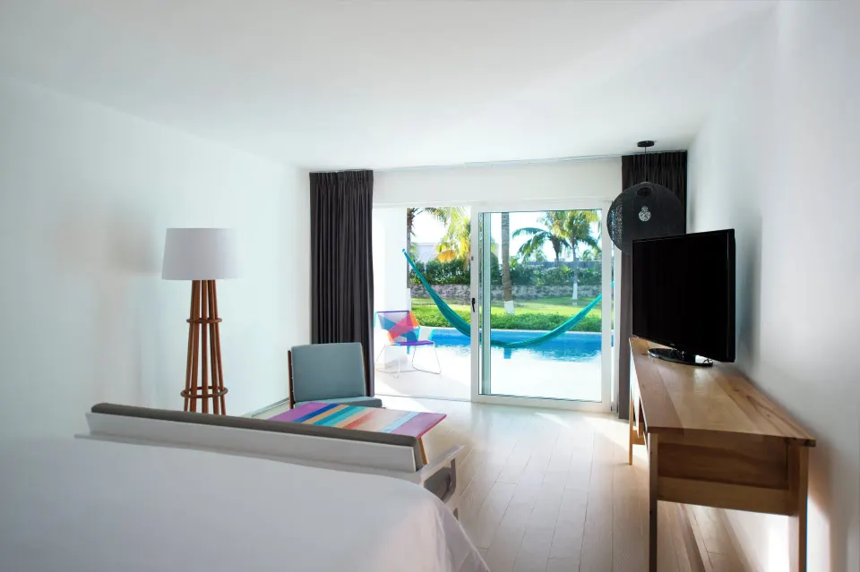 Master Suite king bed beside lounge and plunge pool terrace at Fiesta Americana Cozumel.