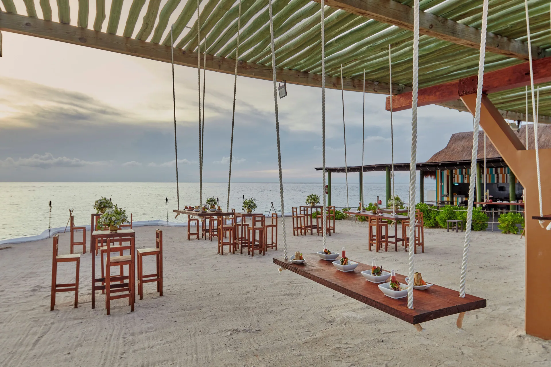 Beachfront event tables and a hanging food display are set up at Fiesta Americana Cozumel.