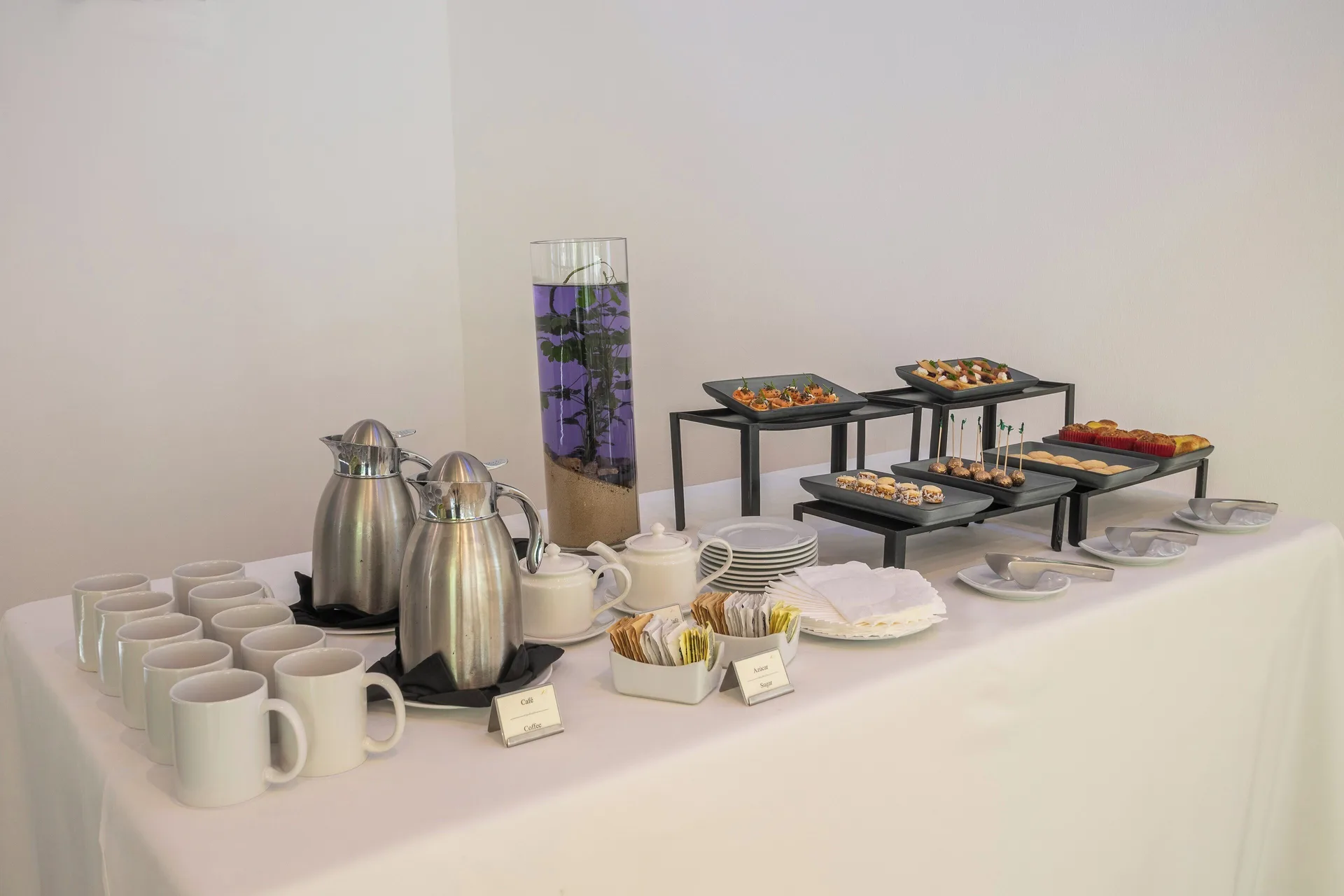 Coffee, cups, and plated snacks on a meeting refreshment table at Fiesta Americana Cozumel.