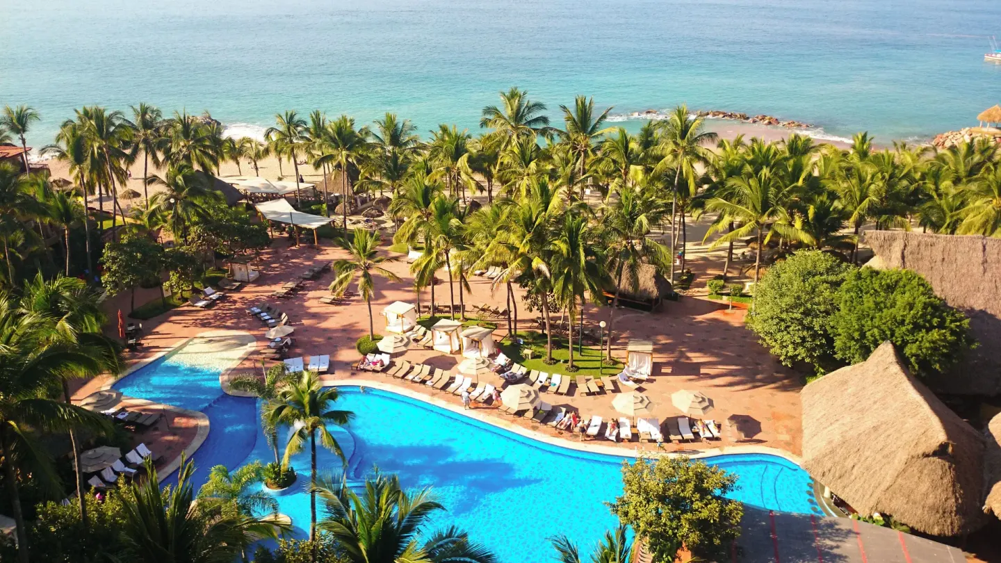 Aerial view of pool, palms, beach, and ocean at Fiesta Americana Puerto Vallarta & Spa.