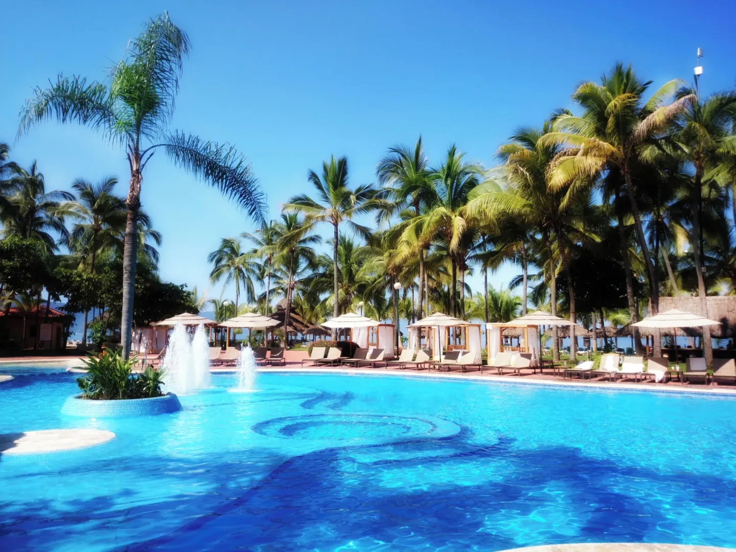 Bright pool with fountains and cabanas at Fiesta Americana Puerto Vallarta & Spa.
