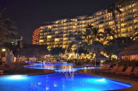 Nighttime illuminated pool and hotel tower at Fiesta Americana Puerto Vallarta & Spa.