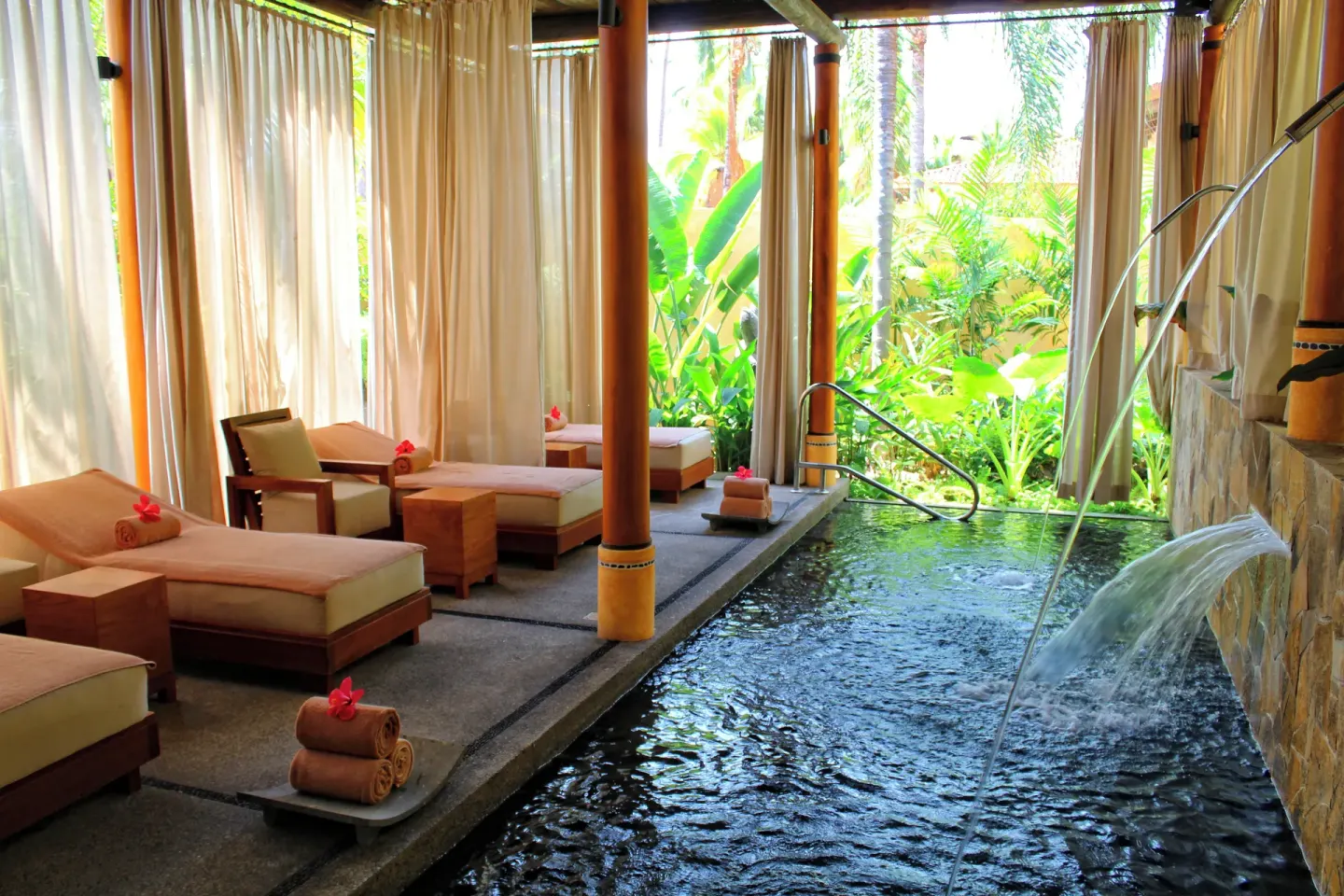 Spa relaxation area with loungers and a water feature at Fiesta Americana Puerto Vallarta & Spa.