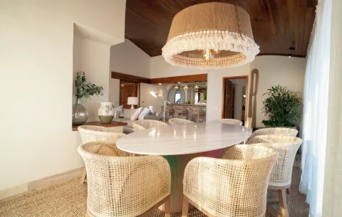Suite dining table with woven chairs and pendant light at Fiesta Americana Puerto Vallarta & Spa.