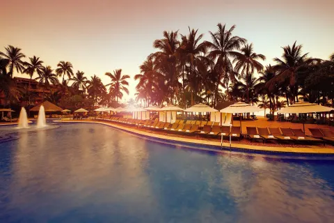 Sunset pool with loungers and palms at Fiesta Americana Puerto Vallarta & Spa.