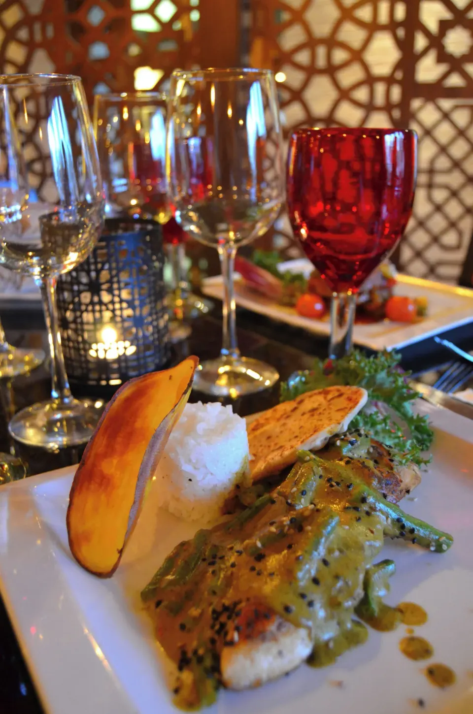 Plated seafood with rice and wine glasses at Fiesta Americana Puerto Vallarta & Spa.