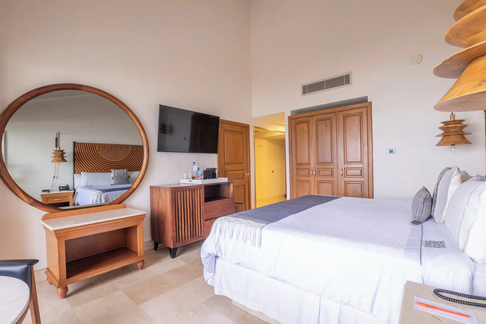 Club Room king bed with dresser, mirror, and wardrobe at Fiesta Americana Puerto Vallarta & Spa.