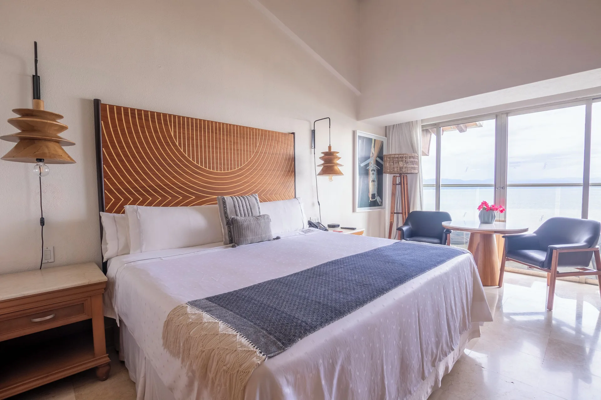 Club Room king bed with carved headboard and seating area at Fiesta Americana Puerto Vallarta & Spa.