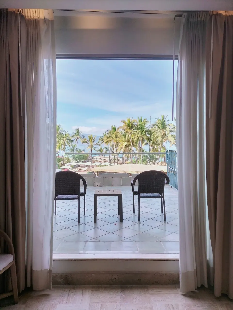 Family Room balcony with chairs and palm views at Fiesta Americana Puerto Vallarta & Spa.