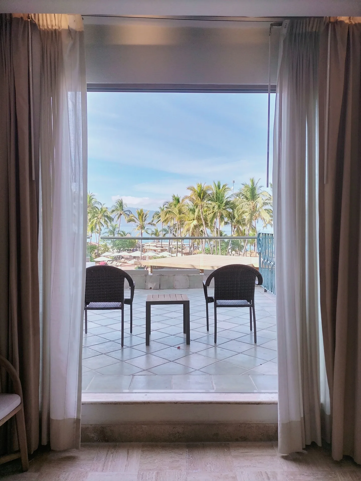 Family Room balcony with chairs and palm views at Fiesta Americana Puerto Vallarta & Spa.